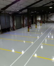 2 part top coat commercial military grade re topcoating kit applied to car warehouse - grey base with white and yellow lines